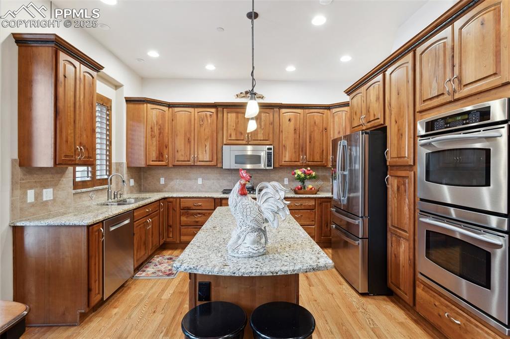 Image 11 of 49: Stainless steel appliances include double ovens, a dishwasher, cooktop, mic