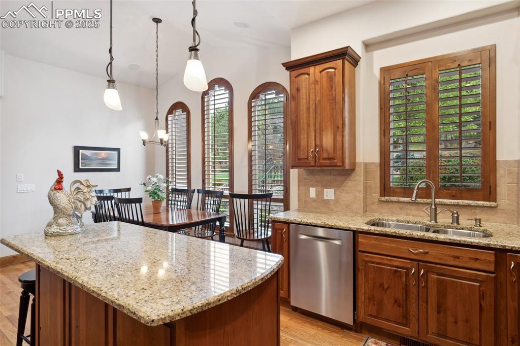 Image 12 of 49: Granite island with breakfast bar and pendant lights.
