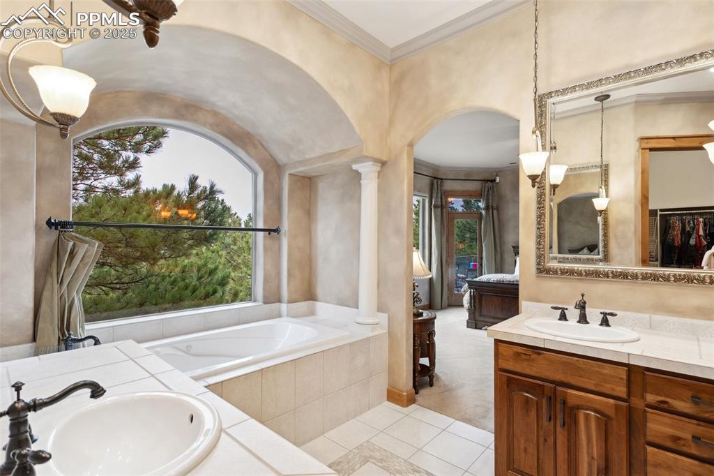 Image 22 of 49: Luxurious 5-Piece Primary Bathroom with view into the Primary Bedroom.