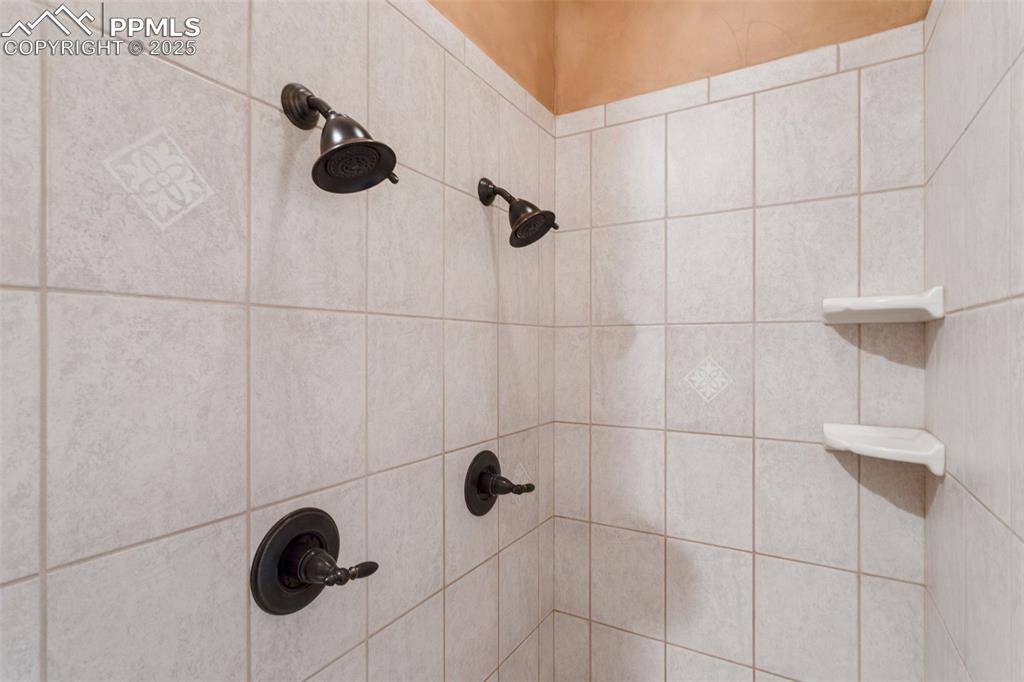 Image 24 of 49: Tiled shower with dual shower heads in the Primary 5-Piece Bathroom.