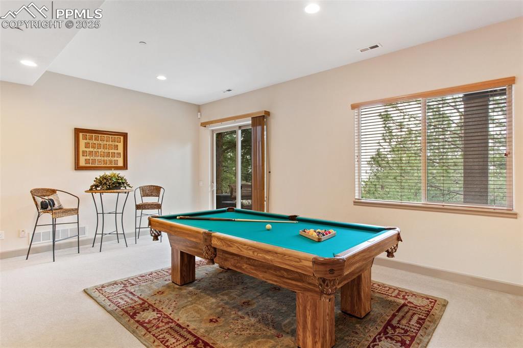 Image 37 of 49: There is also a Game Area in the Basement with walk out to the backyard pat