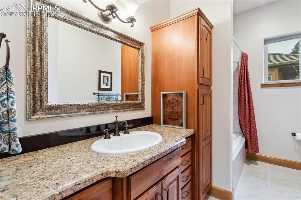 Image 46 of 49: Basement Bathroom with vanity, framed mirror, linen cabinet, and tub/shower
