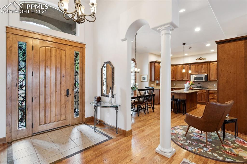 Image 5 of 49: Interior tiled Entry with archway and pillar into the Gourmet Island Kitche