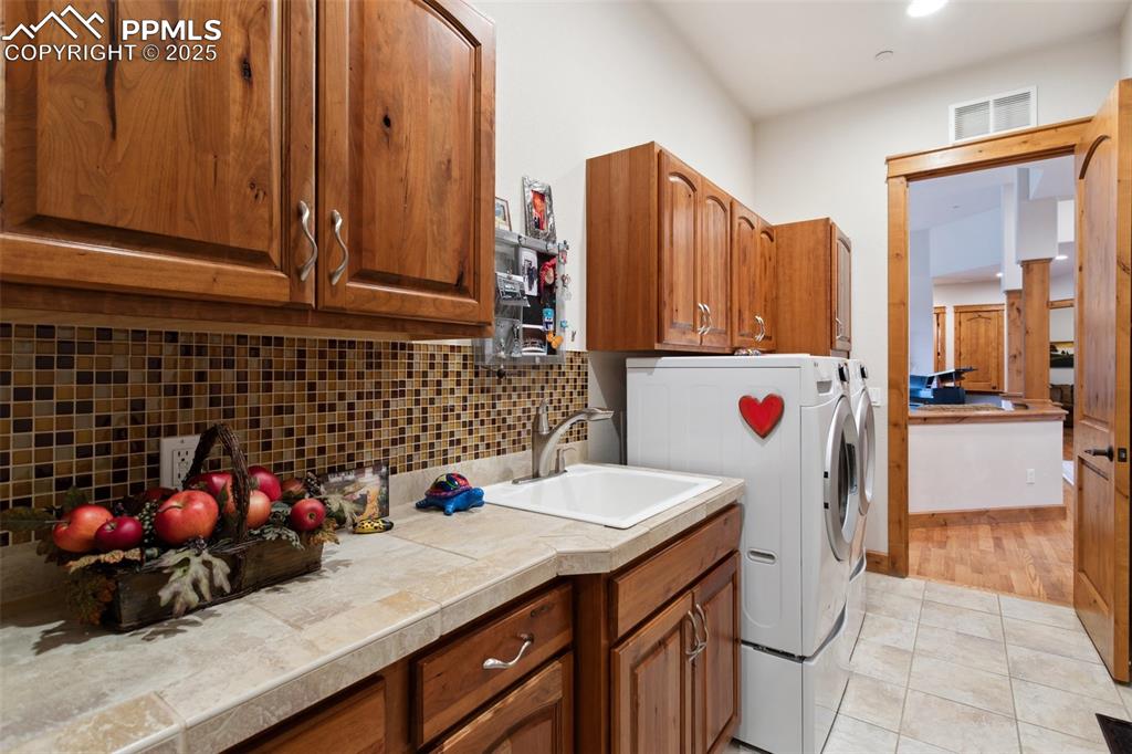 Image 7 of 49: The Laundry Room is located off the Living Room and features a tile floor,