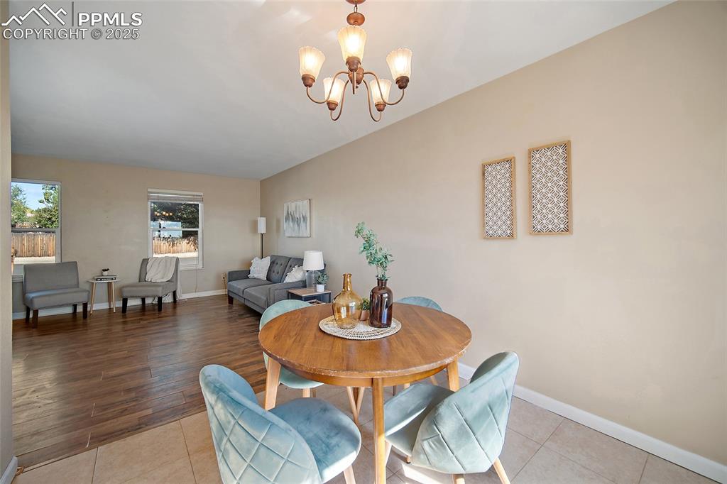 Image 11 of 45: Dining room with a chandelier and light tile patterned flooring