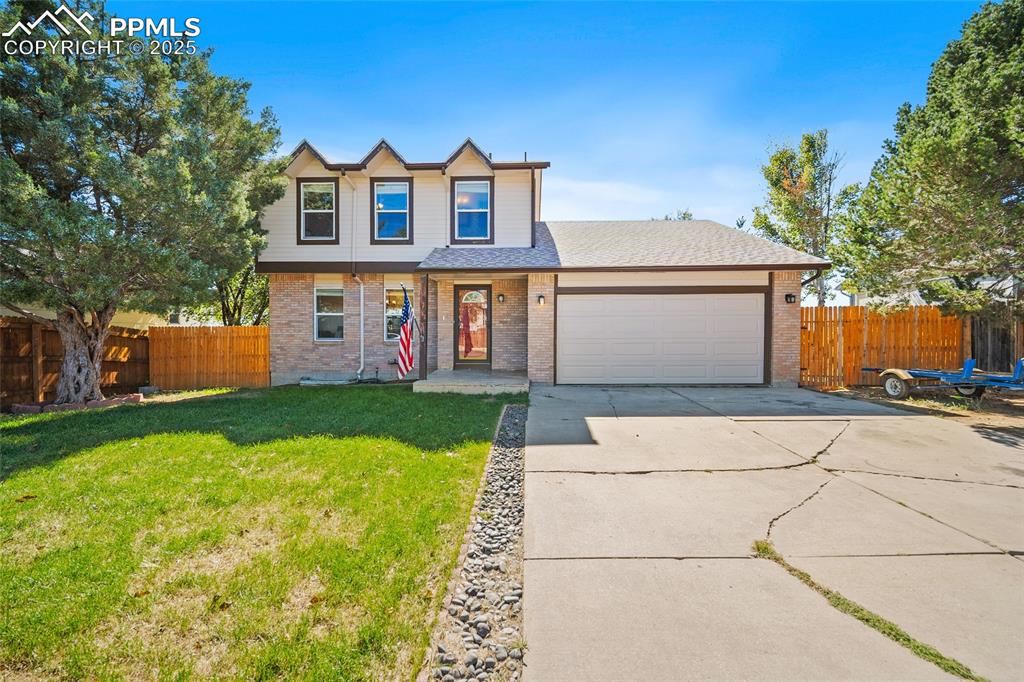 Image 2 of 45: Traditional home with brick siding, concrete driveway, roof with shingles,