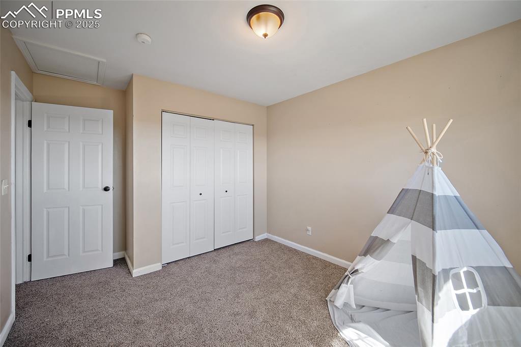 Image 26 of 45: Rec room with carpet floors and attic access