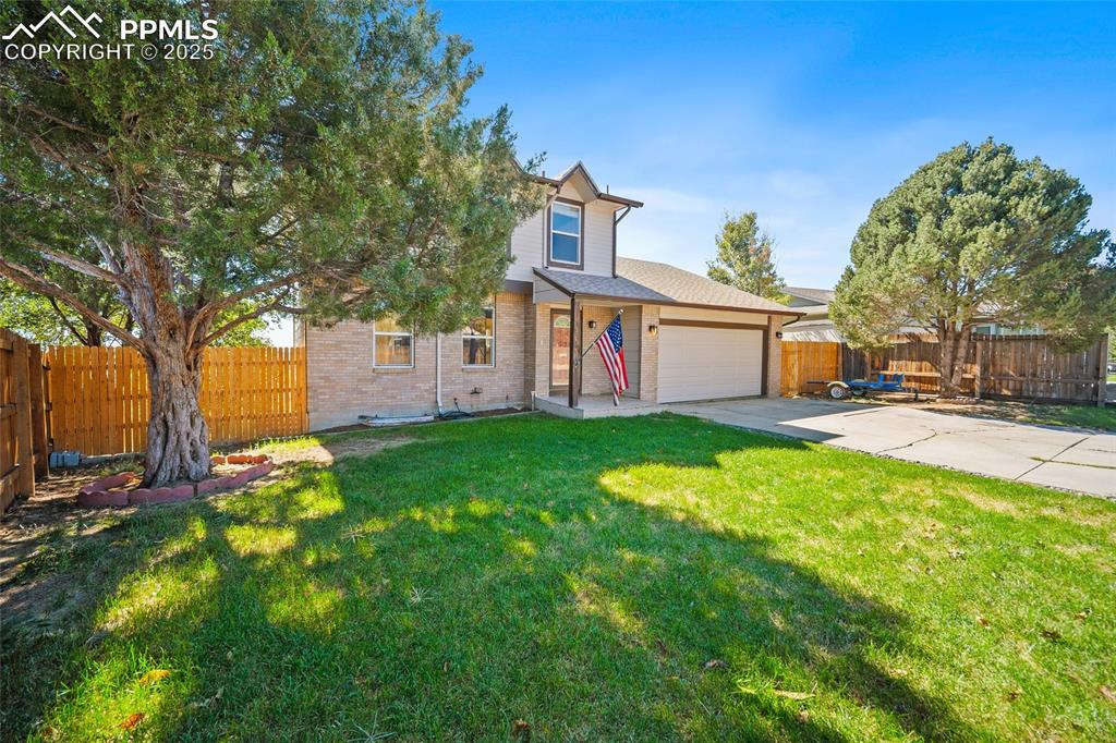 Image 3 of 45: View of front of house featuring brick siding, driveway, and an attached ga