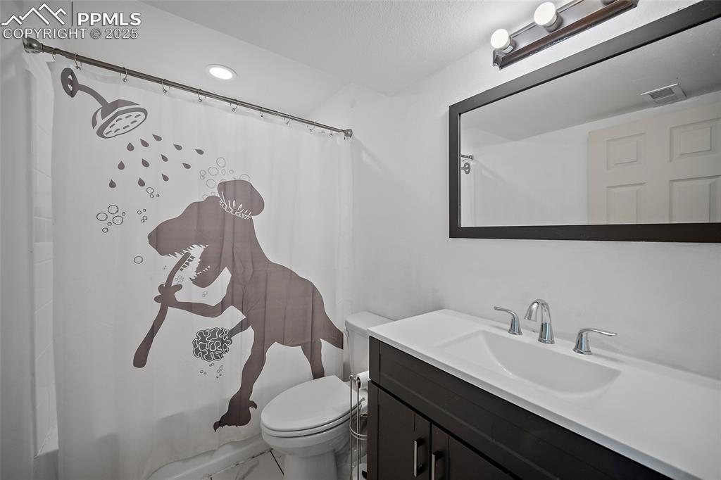 Image 35 of 45: Full bathroom featuring vanity, shower / bath combo with shower curtain, an