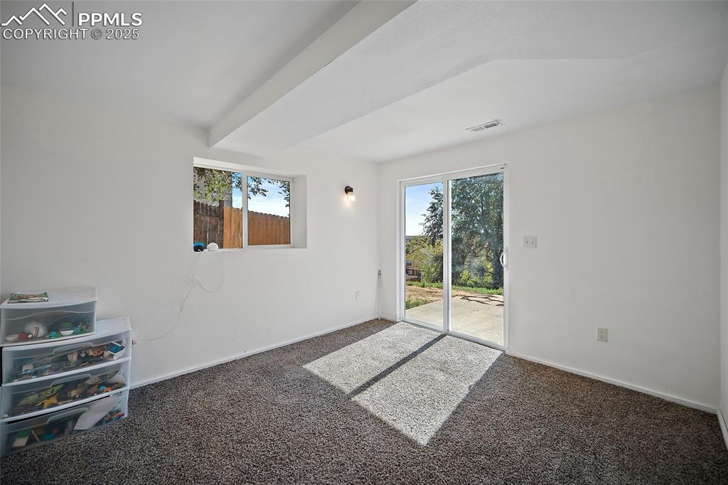 Image 36 of 45: Empty room with plenty of natural light and carpet flooring