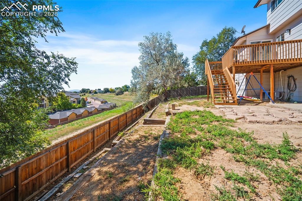 Image 39 of 45: Fenced backyard featuring a patio area, a deck, and stairs