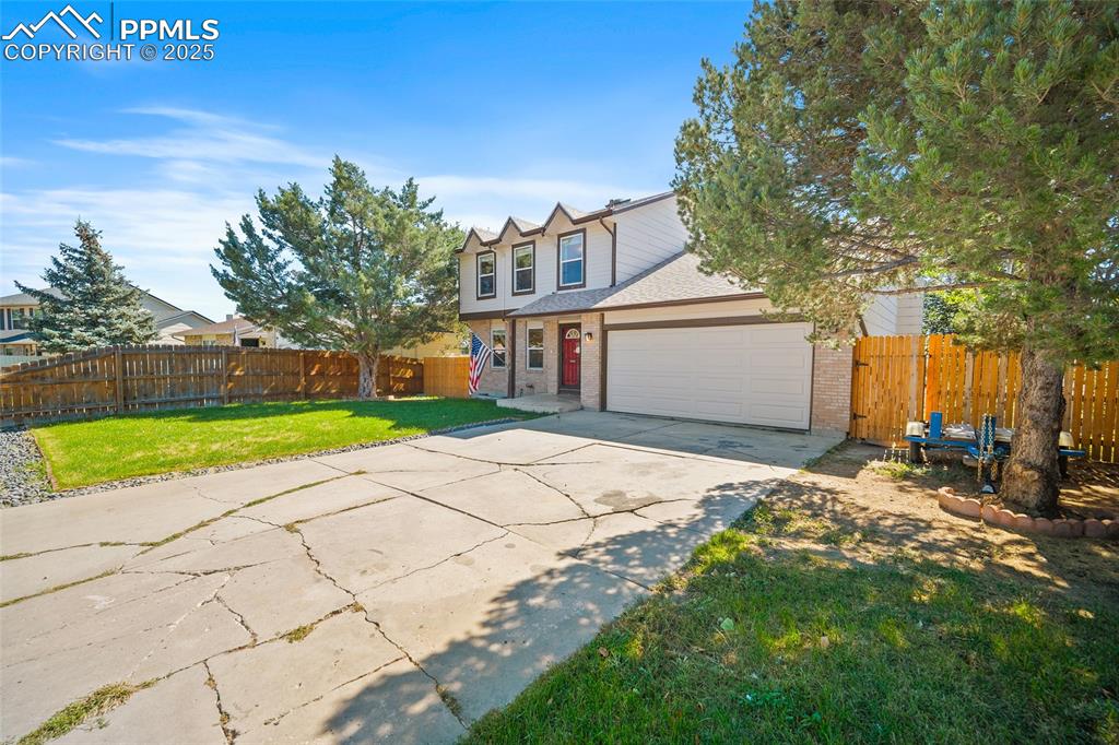 Image 4 of 45: Traditional home with concrete driveway, brick siding, a garage, and a shin