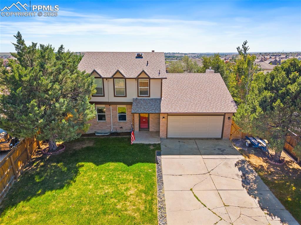 Image 41 of 45: View of front of home with roof with shingles, driveway, brick siding, a ga