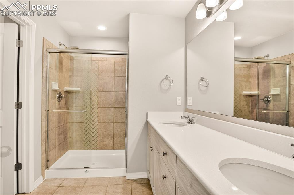 Image 25 of 38: Primary suite bathroom has spacious shower with seat, rain shower head, sha