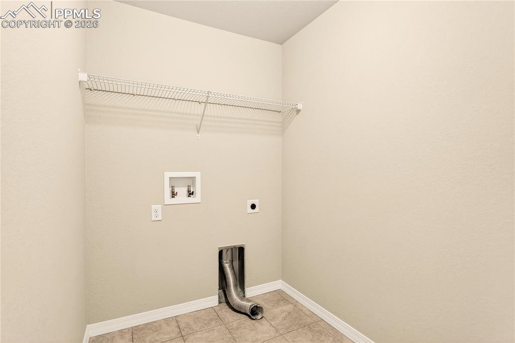 Image 31 of 38: Upper level laundry has extra storage space and electric hookups for your