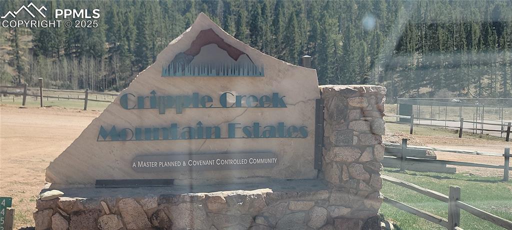 Image 11 of 23: Community / neighborhood sign with a wooded view