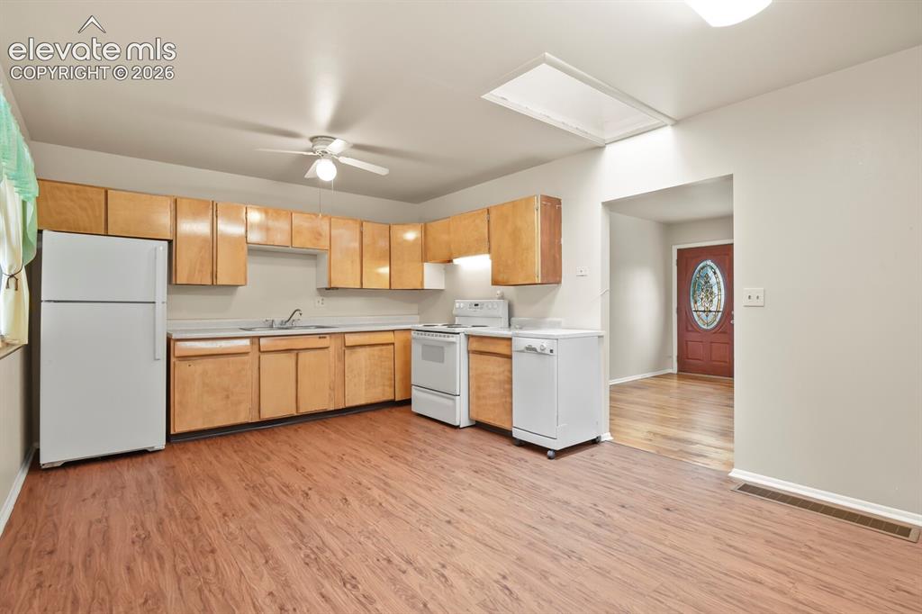 Image 10 of 45: Far corner of kitchen by back door looking toward living room and front doo