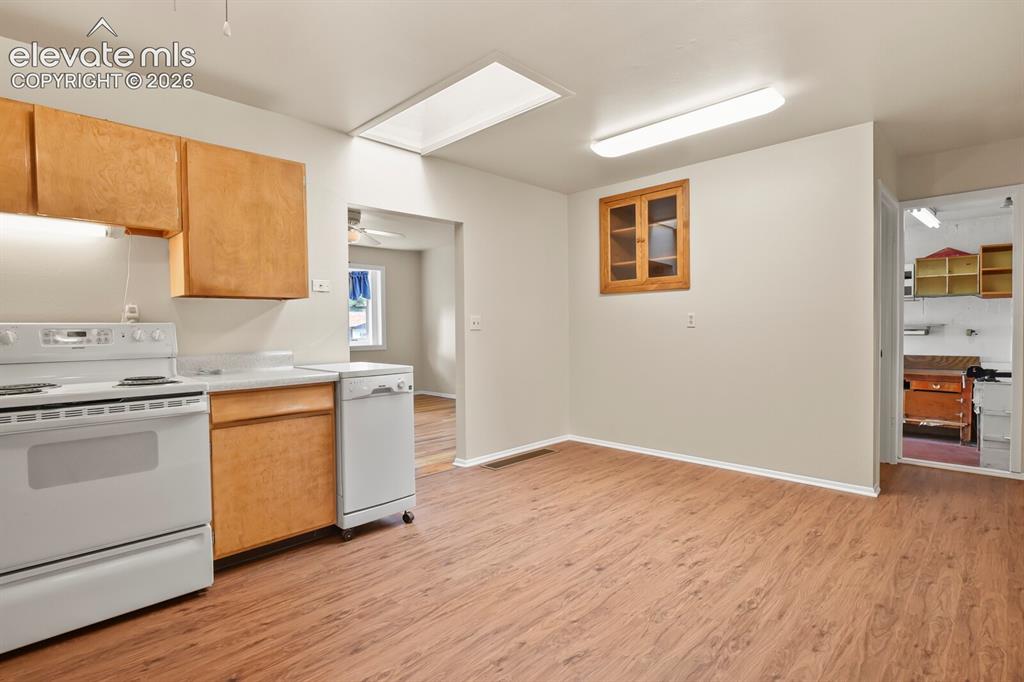 Image 13 of 45: Corner of kitchen looking toward living room and workshop area.