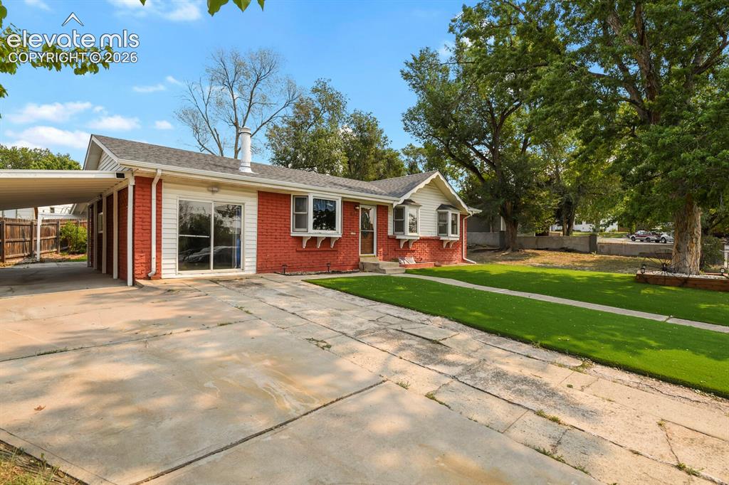 Image 2 of 45: Driveway, carport, front of structure.