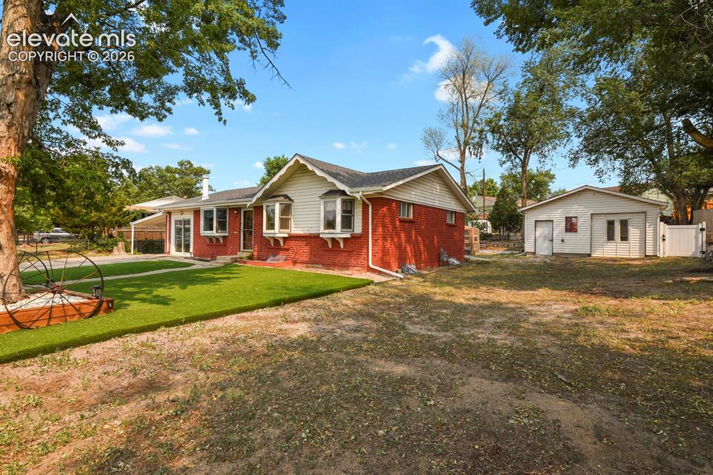 Image 3 of 45: Far corner of lot showing house, yard, and detached shop.