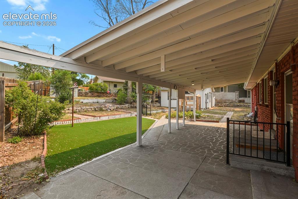 Image 40 of 45: Covered patio and part of backyard.