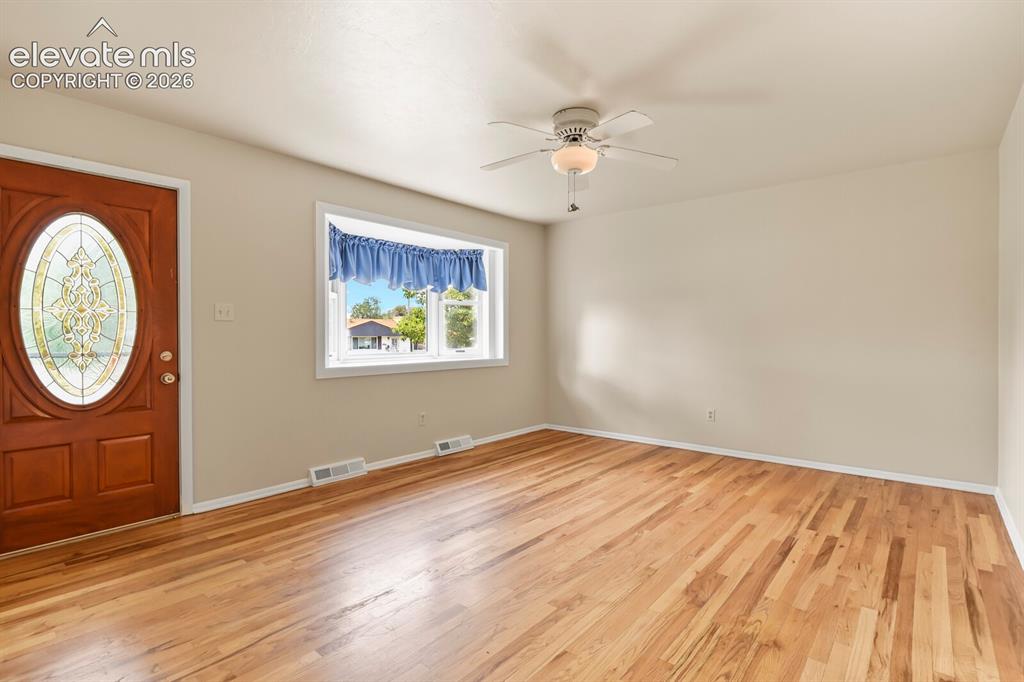 Image 6 of 45: From hallway looking at front door, bay window, and living room.