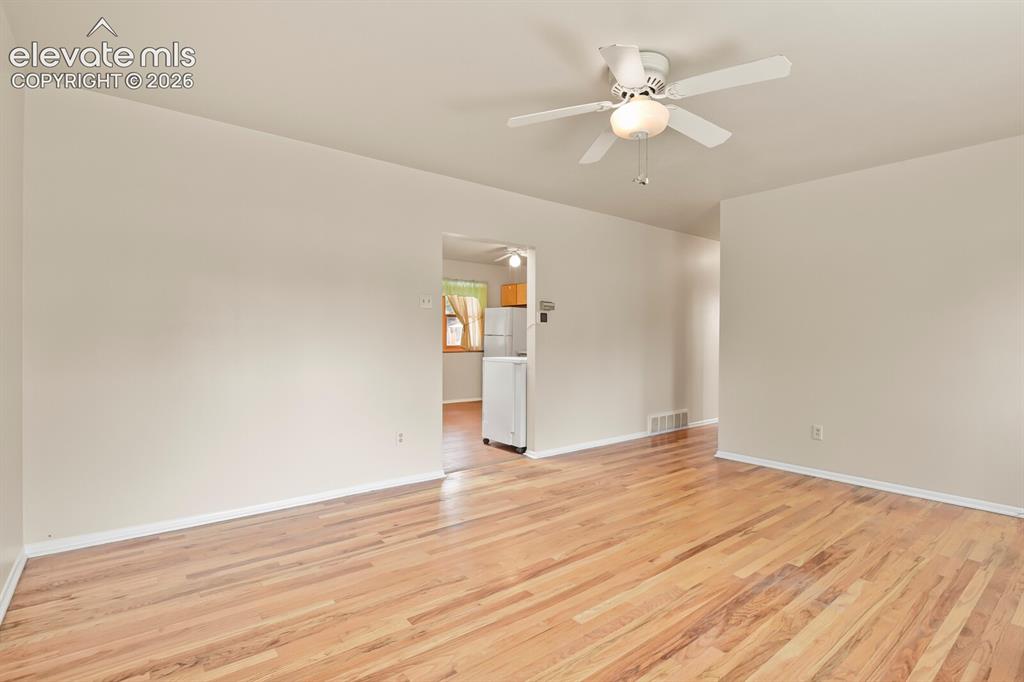 Image 8 of 45: Front corner of living room looking toward hallway and kitchen.