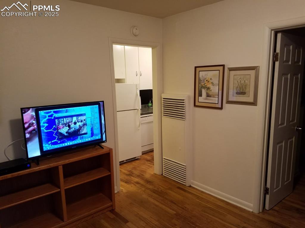 Image 17 of 25: Living room featuring a heating unit and wood finished floors
