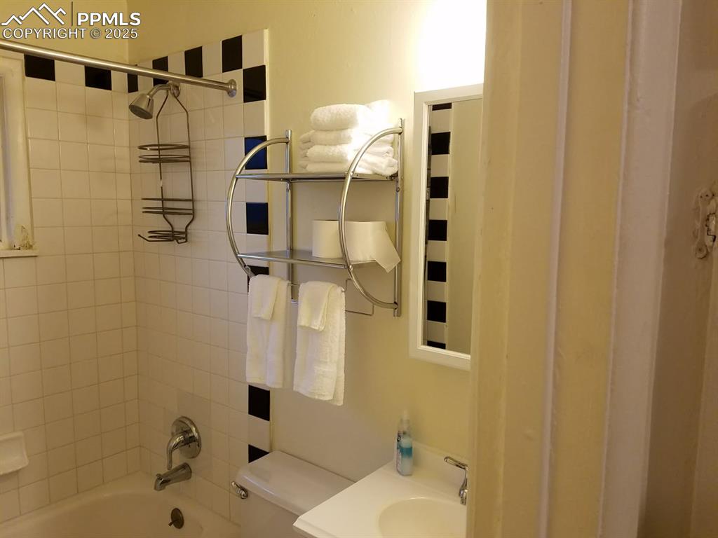 Image 20 of 25: Bathroom featuring toilet, washtub / shower combination, and vanity