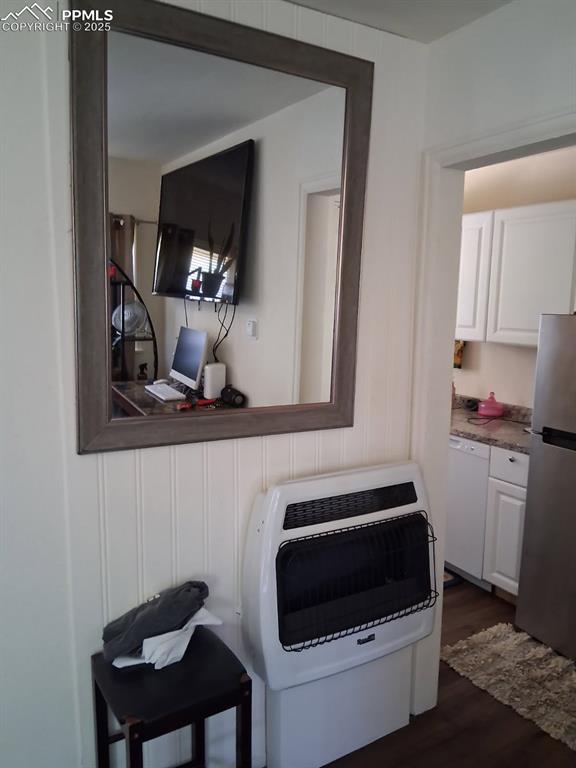 Image 24 of 25: Laundry view of white dishwasher, freestanding refrigerator, heating unit,