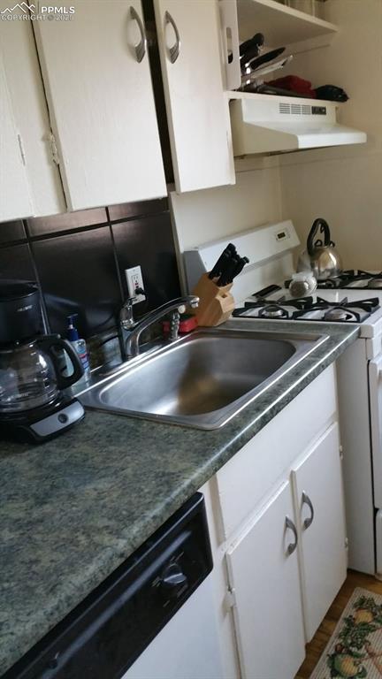 Image 6 of 25: Kitchen with white appliances, under cabinet range hood, white cabinets, an