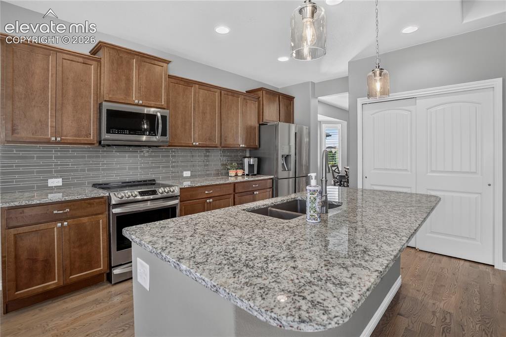 Image 7 of 29: Kitchen features an island & granite counters