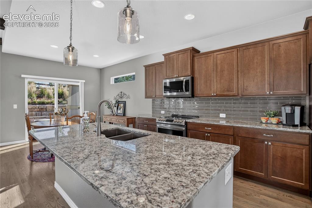 Image 8 of 29: SS appliances & tile backsplash