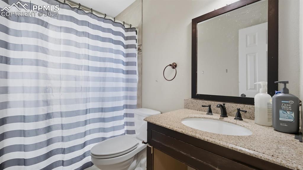 Image 21 of 34: Upper Level Full Bathroom with vanity, framed mirror, and tiled tub/shower.