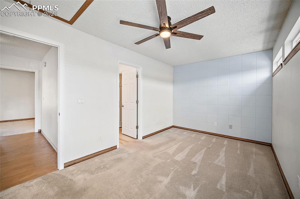 Image 24 of 41: Unfurnished bedroom featuring carpet, a textured ceiling, and ceiling fan