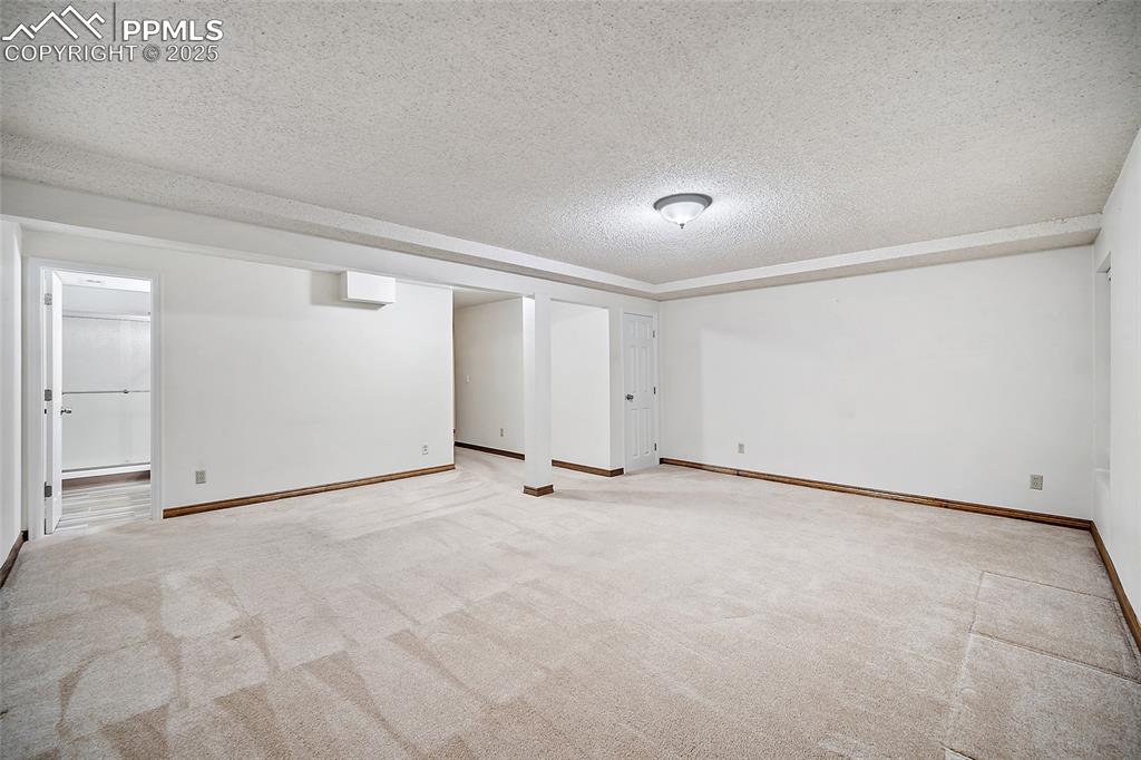 Image 27 of 41: Finished basement featuring a textured ceiling and carpet