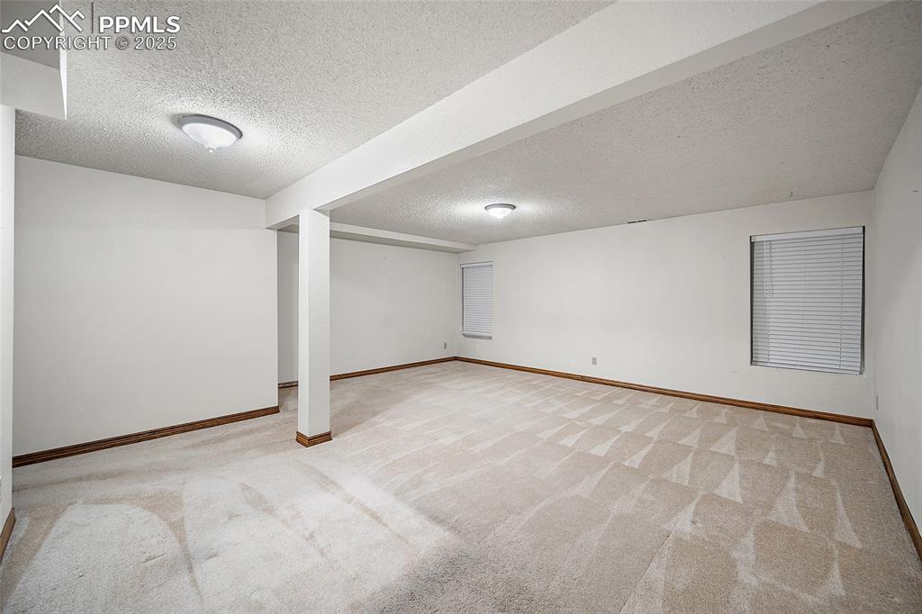 Image 28 of 41: Finished below grade area with a textured ceiling and carpet