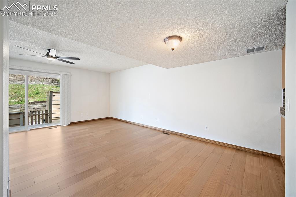 Image 6 of 41: Unfurnished room with light wood-type flooring, a textured ceiling, and a c