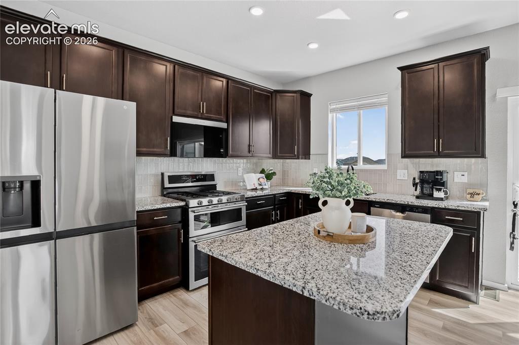 Image 8 of 29: Kitchen w/ stone counters