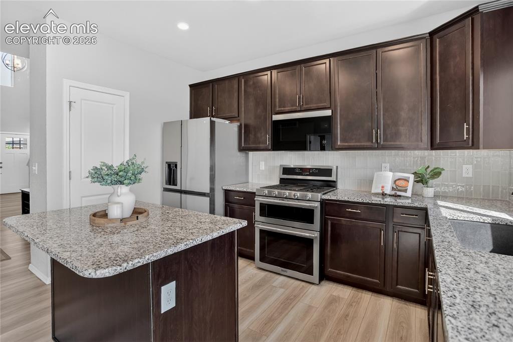 Image 9 of 29: Kitchen w/ stone counters