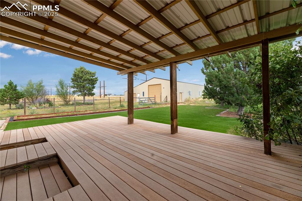 Image 11 of 48: Deck with a lawn and an outdoor structure