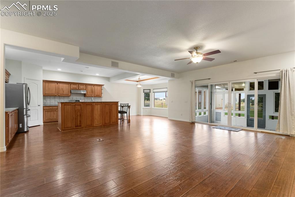 Image 18 of 48: Unfurnished living room with dark wood-style flooring, ceiling fan, and rec