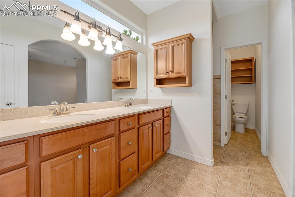 Image 28 of 48: Bathroom featuring light tile patterned floors and double vanity