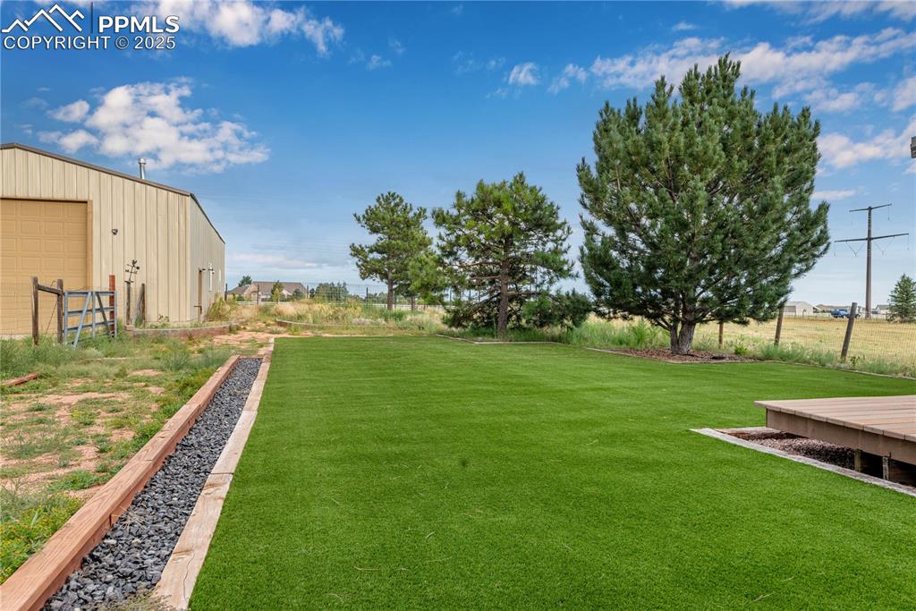 Image 3 of 48: View of green lawn with an outdoor structure and a detached garage