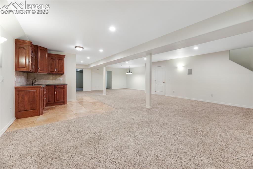 Image 31 of 48: Finished basement with light carpet, recessed lighting, and light tile patt