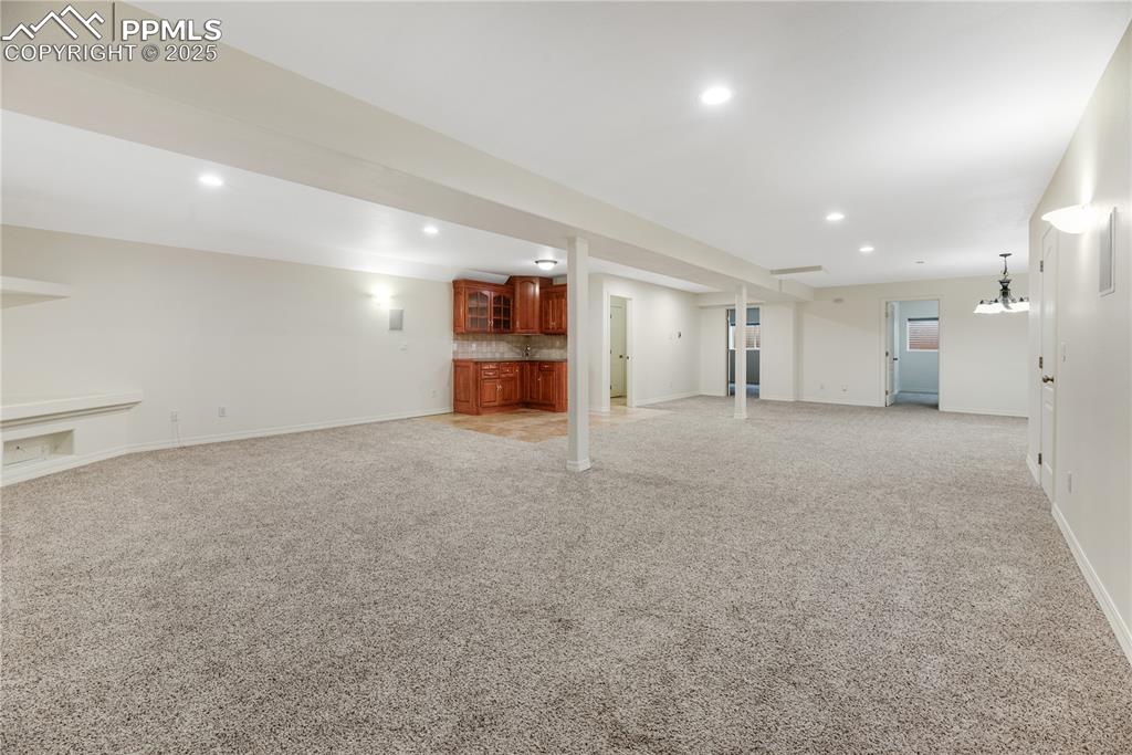 Image 43 of 48: Finished below grade area featuring recessed lighting, wet bar, and light c