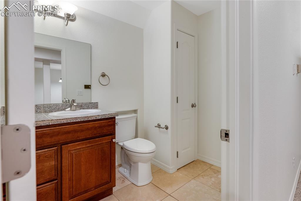 Image 44 of 48: Half bathroom featuring light tile patterned flooring and vanity