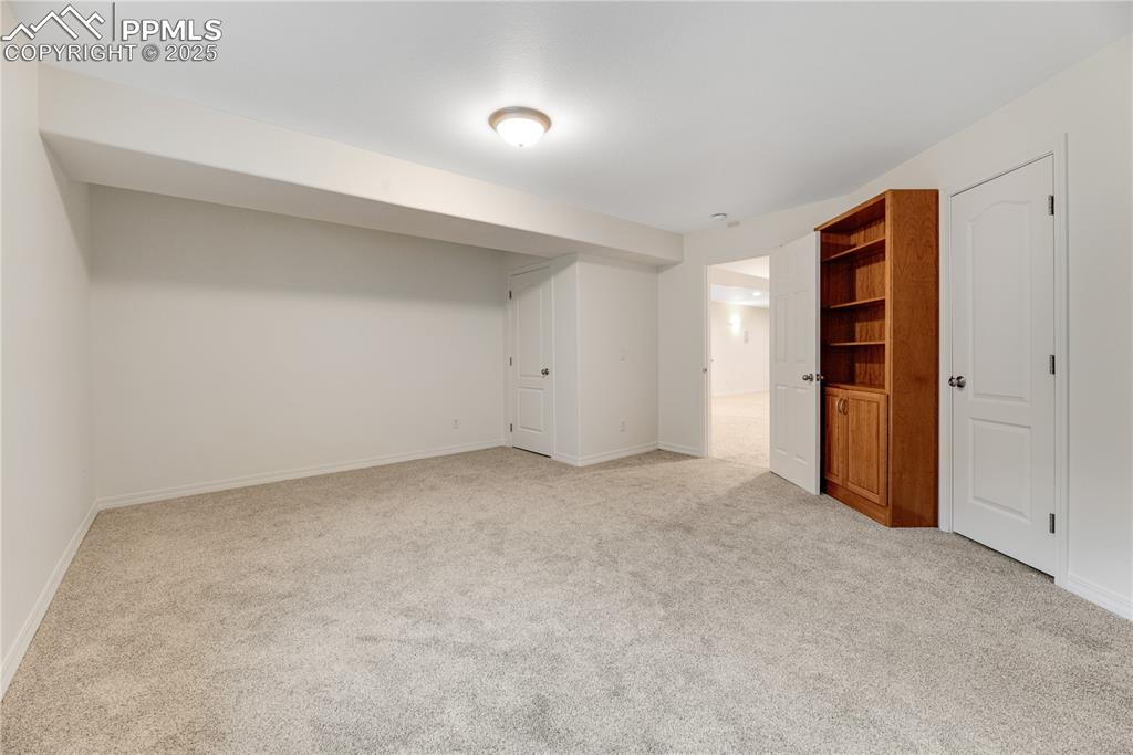 Image 47 of 48: Finished below grade area featuring light colored carpet and baseboards