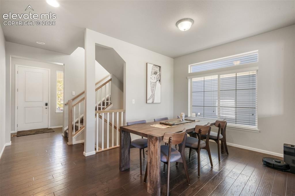 Image 15 of 48: Hardwood-finish flooring, staircase with wood handrails, white paneled entr