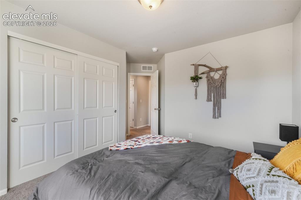 Image 33 of 48: Sliding panel closet doors, neutral wall paint, and carpet flooring